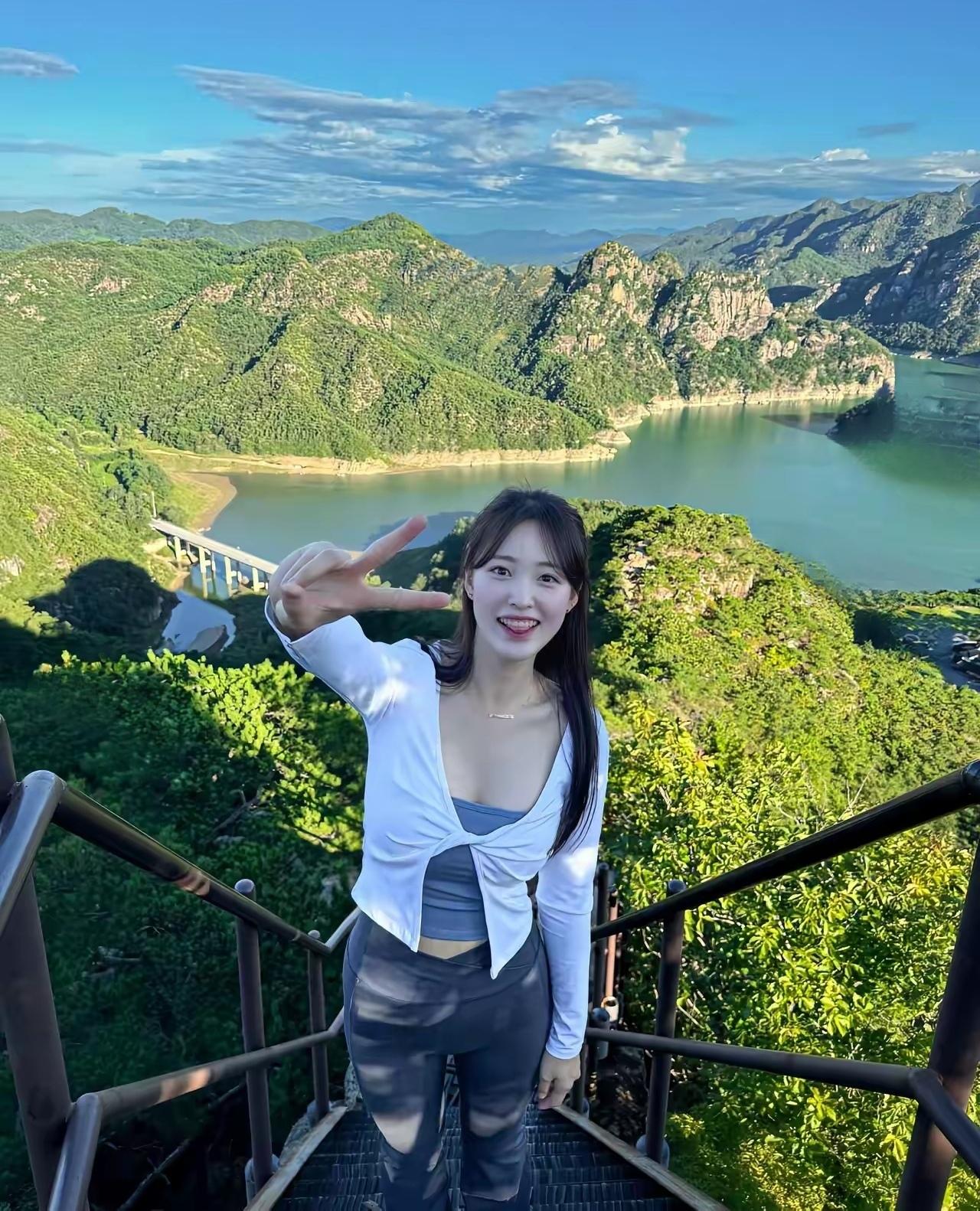 在山顶风景美如画，开心比个V字手势！