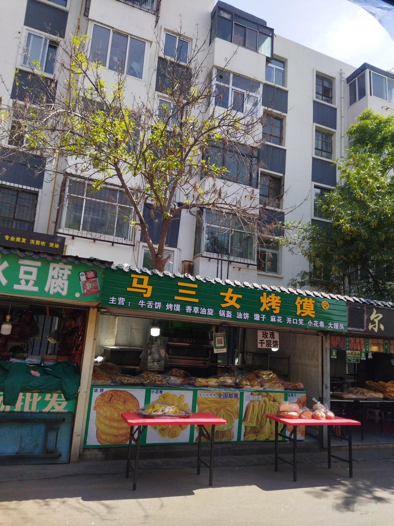 这是某市场的摊位，建设摊位时很多树木都正好建在摊位里，其它的摊位里的摊主可能经常