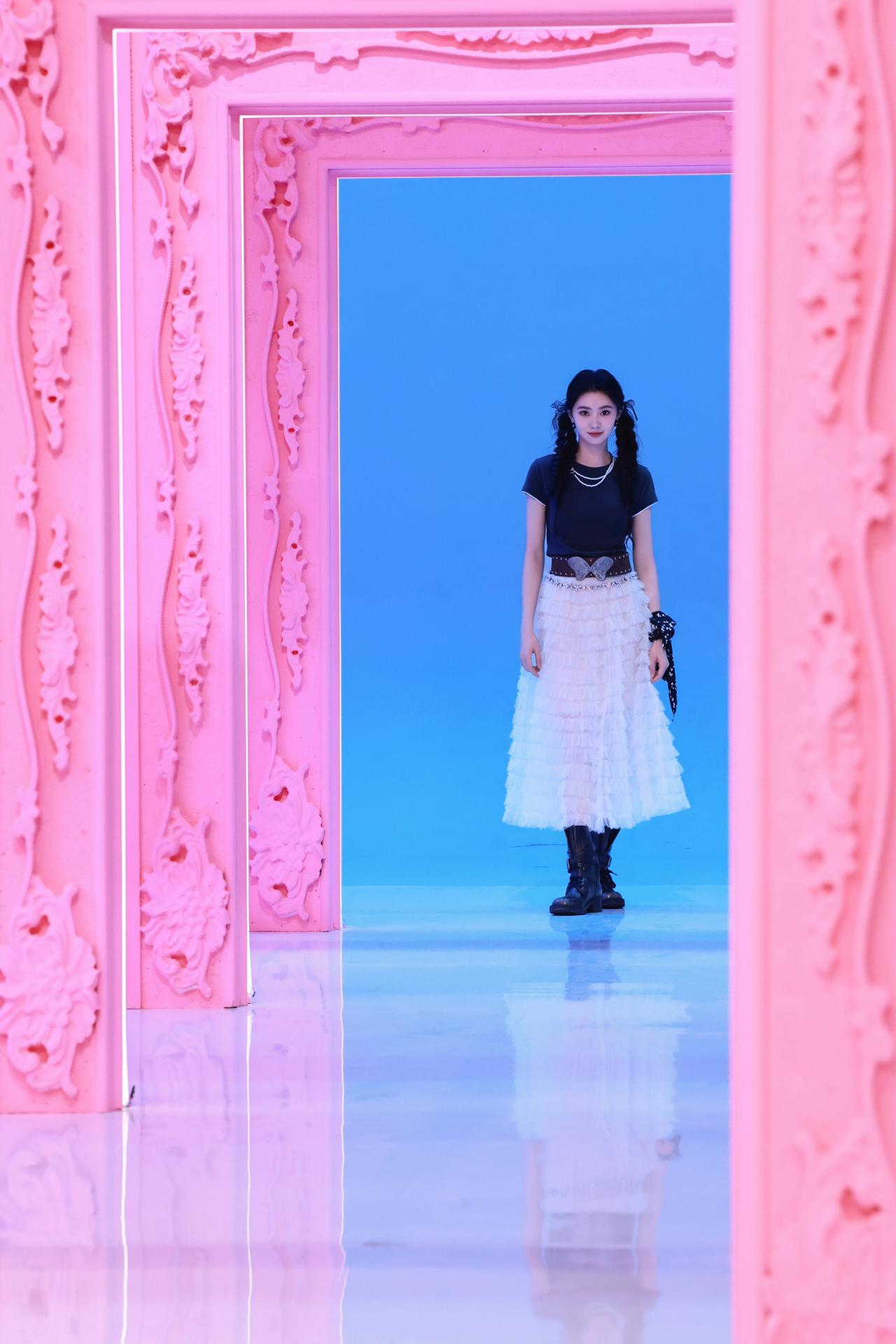 粉调拱门铺展梦幻通道，澄澈蓝天衬满元气少女感。

黑T碰撞蓬蓬白裙，双马尾漾起灵