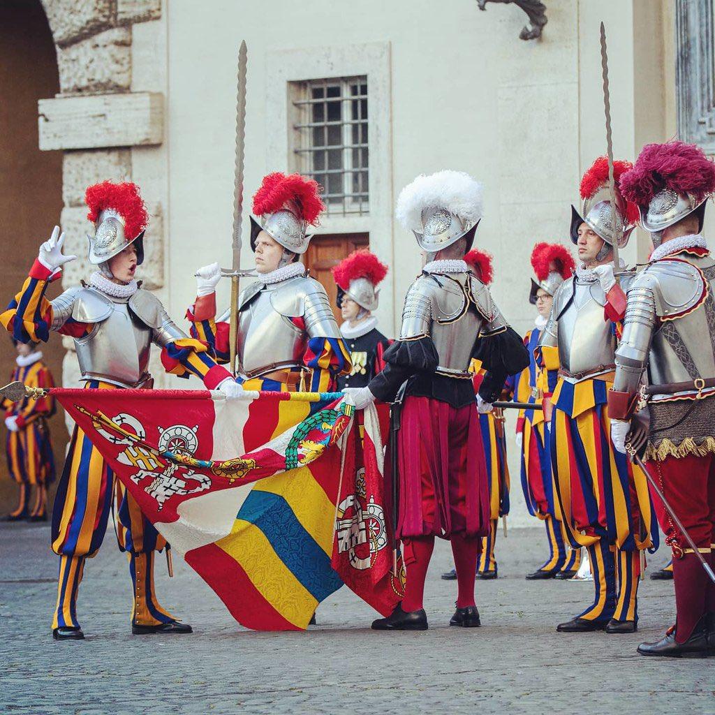 教皇瑞士卫队的标志性16世纪礼仪制服和长柄斧与他们实际使用的现代瑞士制造枪支（包