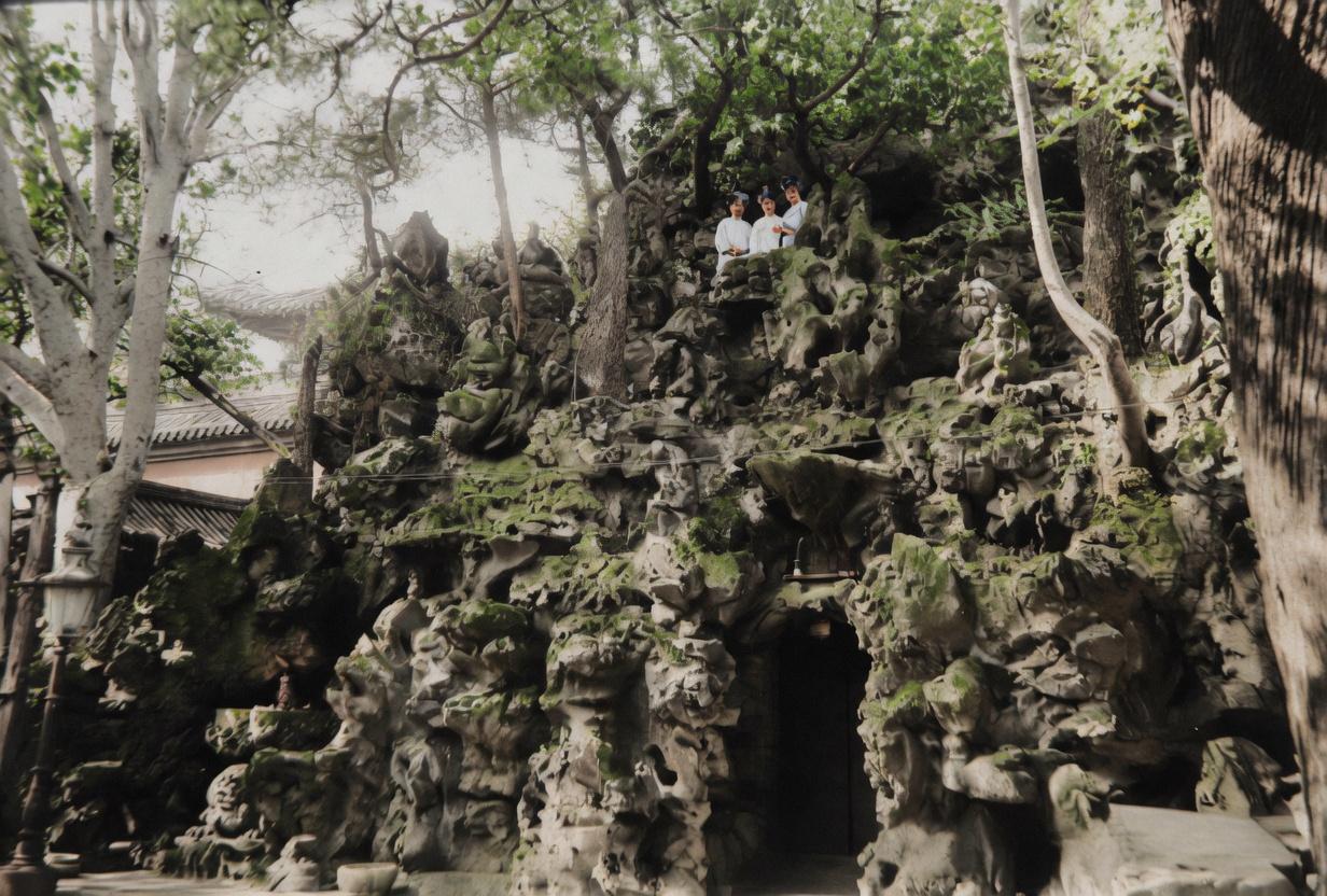 逊清小朝廷时期，紫禁城御花园，婉容、文秀与唐怡莹，坐在太湖石假山上留影。
三人姿