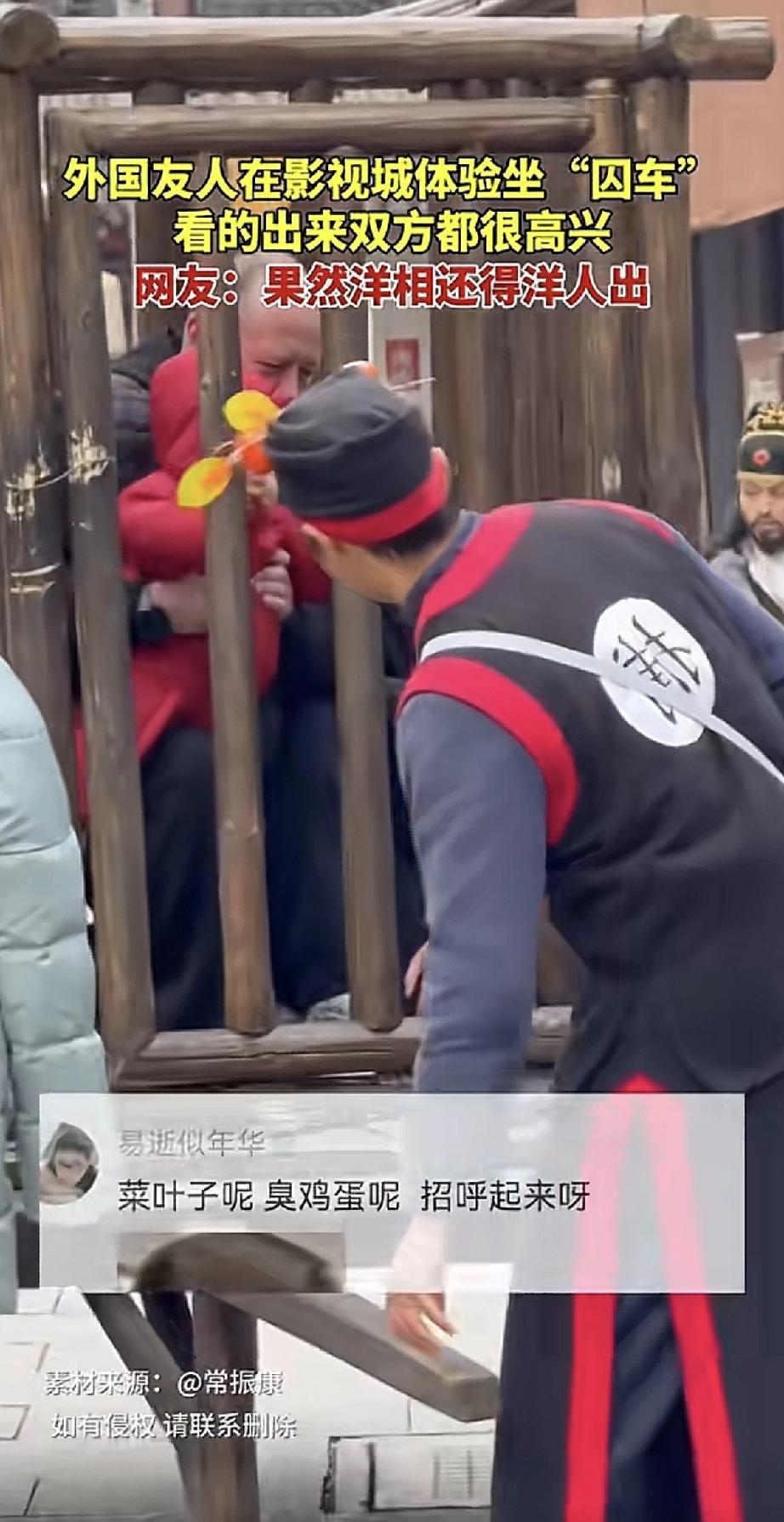 外国友人在影视城游玩，一眼相中了“囚车”体验项目。他乐呵呵地坐进去，把手伸进木枷