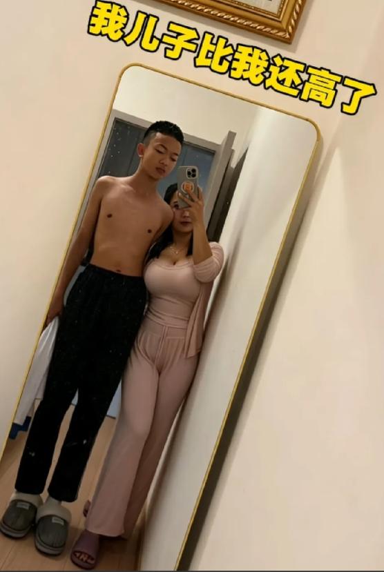 一位母亲看着儿子身高终于超过自己，心里满是欢喜，在家随手拍下一张母子合照，打算发