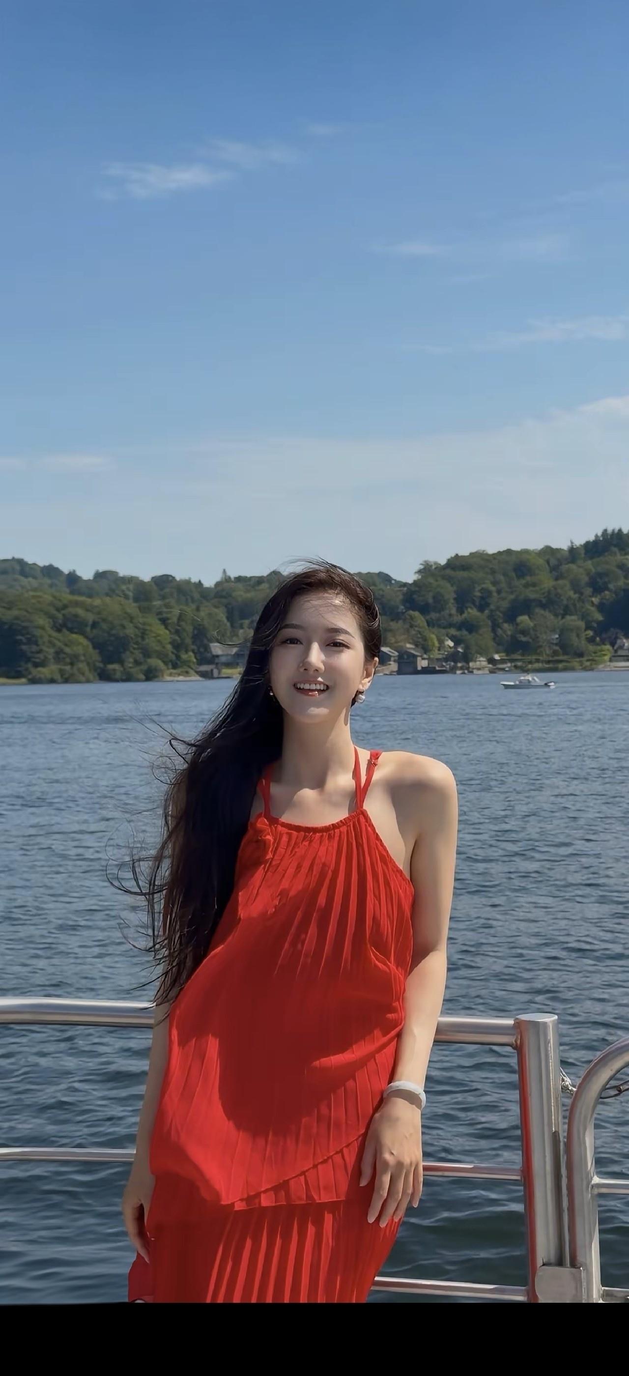 红衣美人倚栏杆，碧波荡漾映笑颜。