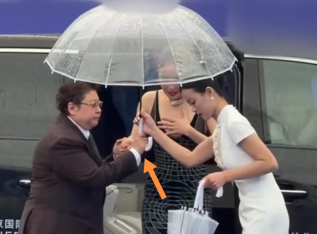 4月17日，北京国际电影节韩红冒雨给高叶撑雨伞。