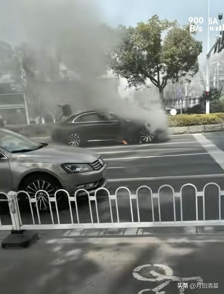 新鲜出炉的汽车自燃事件，地点是江苏，一辆小汽车在斑马线前等待红绿灯，突然底盘冒出