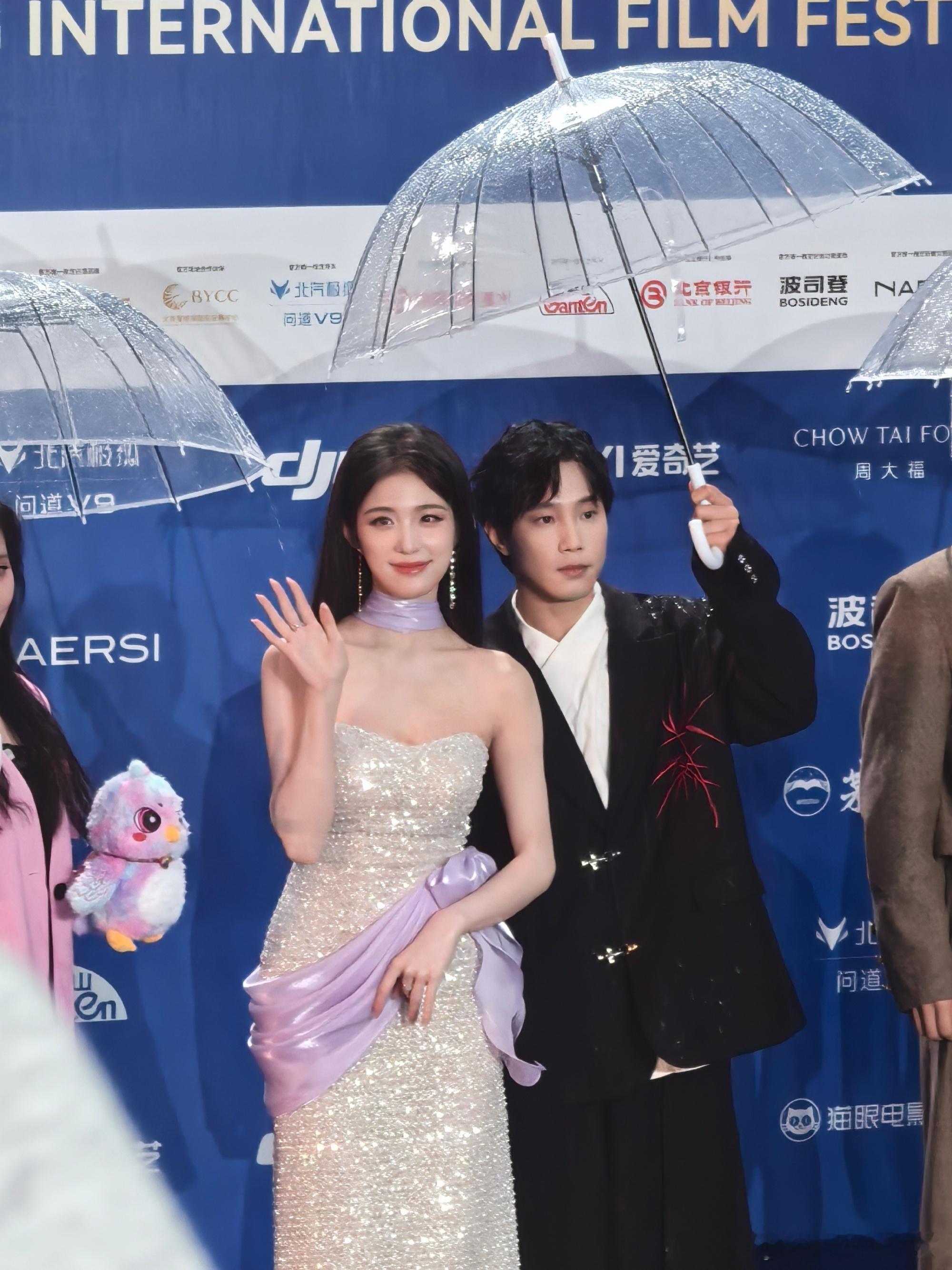 钟丽丽红毯被淋了 钟丽丽收伞后被雨淋也从容，抬手遮雨笑眼弯弯，温柔又大方，雨中状