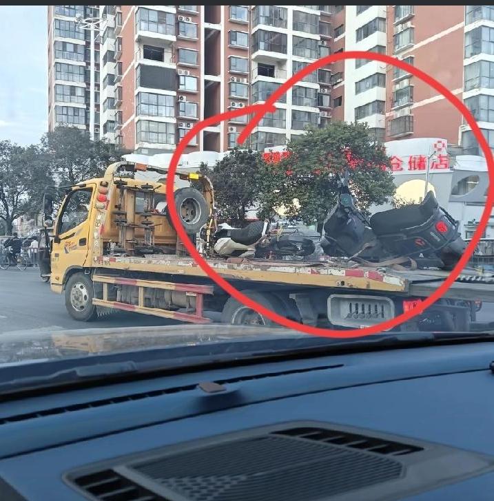 项城公园2辆电动车，被拖车拉走时，当地网友开车偶拍，一辆白色电摩、一辆黑色某迪大