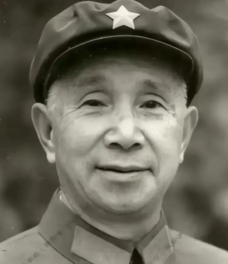粟裕将军经典黑白标准照，红五星熠熠生辉，红领章鲜明夺目。将军面容和蔼含笑，眉眼间