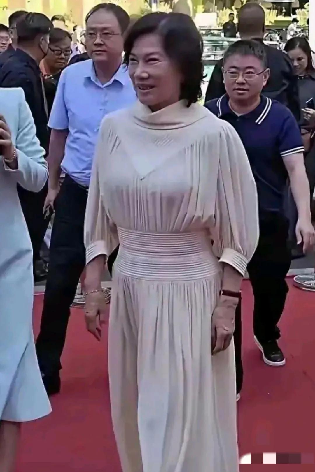 镜头中的董明珠面色偏黑，发型不够精致，眼角皱纹粗粝，笑容牵强，后背微耸，手背青筋