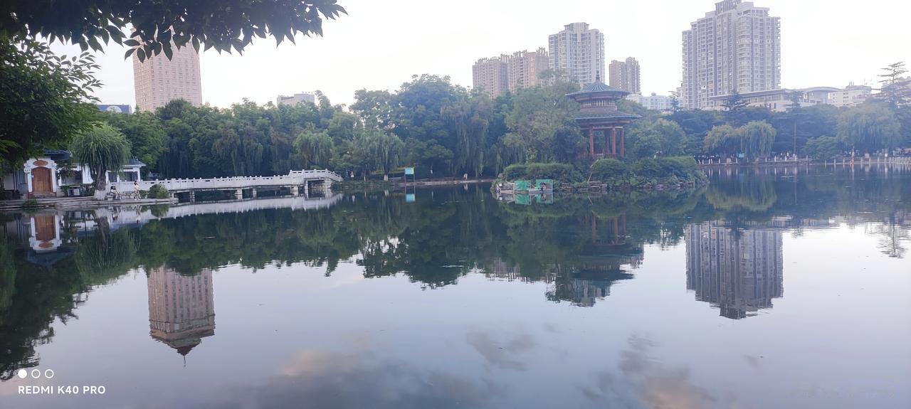 珠江源湖
一湖静水镜光浮，
曲榭弯弯石拱桥。
翠柳垂杨遮岸径，
高楼倒影水中摇。