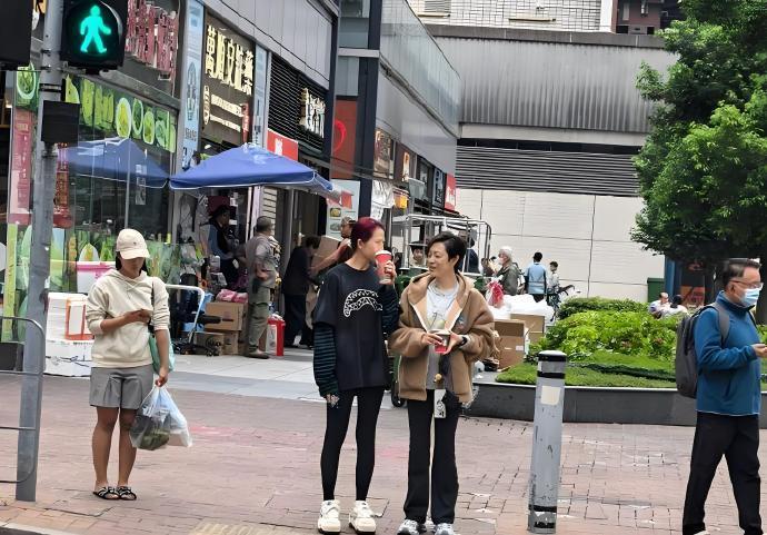 有网友拍到蔡少芬和陈法蓉香港街头逛街等红绿灯，两人一手一杯奶茶，低声交谈，脸上未