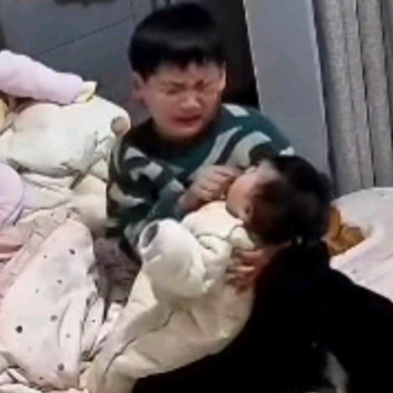 小男孩在家独自照顾妹妹，尝试给她喂奶嘴却怎么也塞不进去，急得崩溃大哭。当天爸妈出