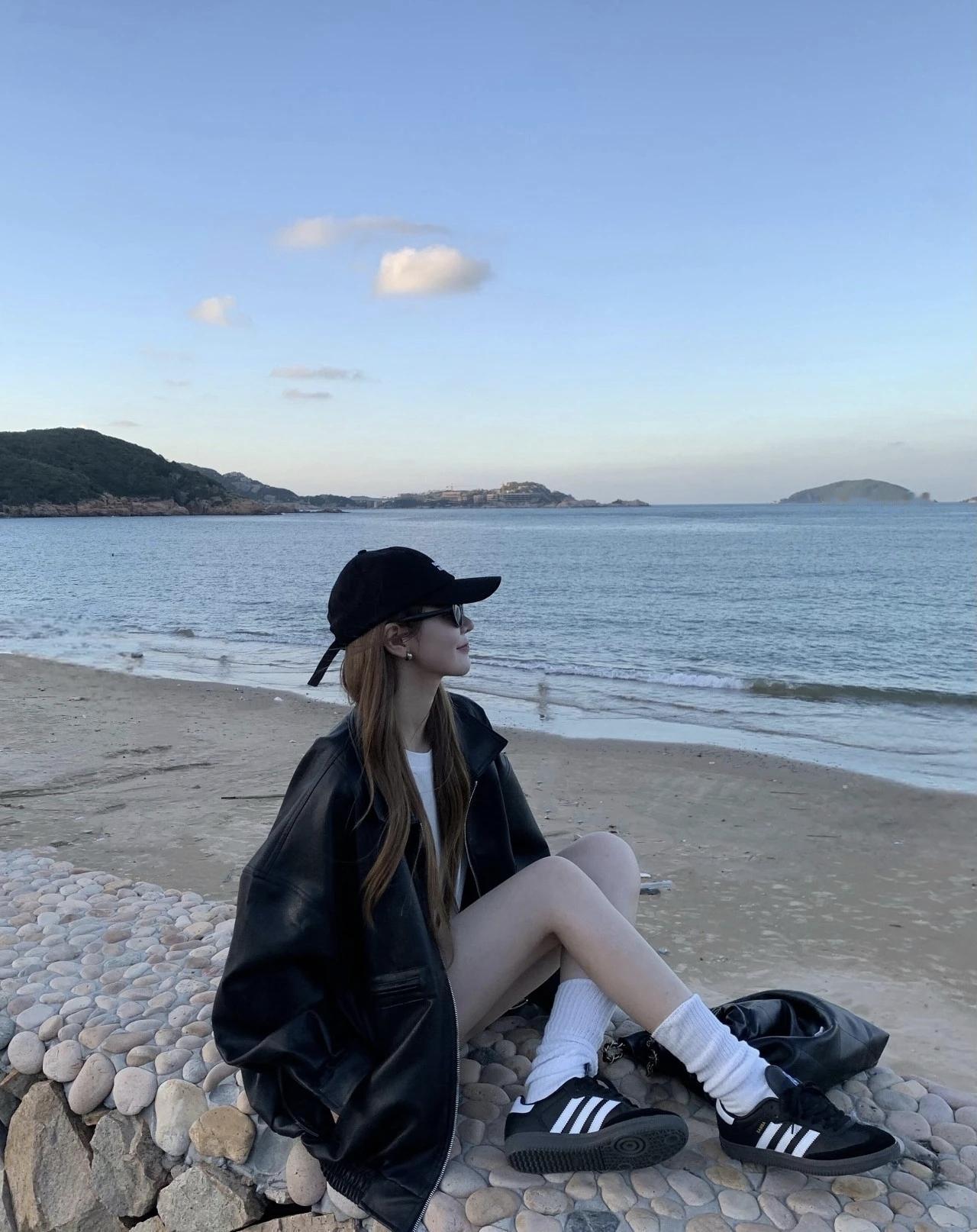 海风裹着浅蓝的暮色漫过礁石，宽松皮衣和棒球帽的酷感，被海浪声柔化成松弛的温柔。就