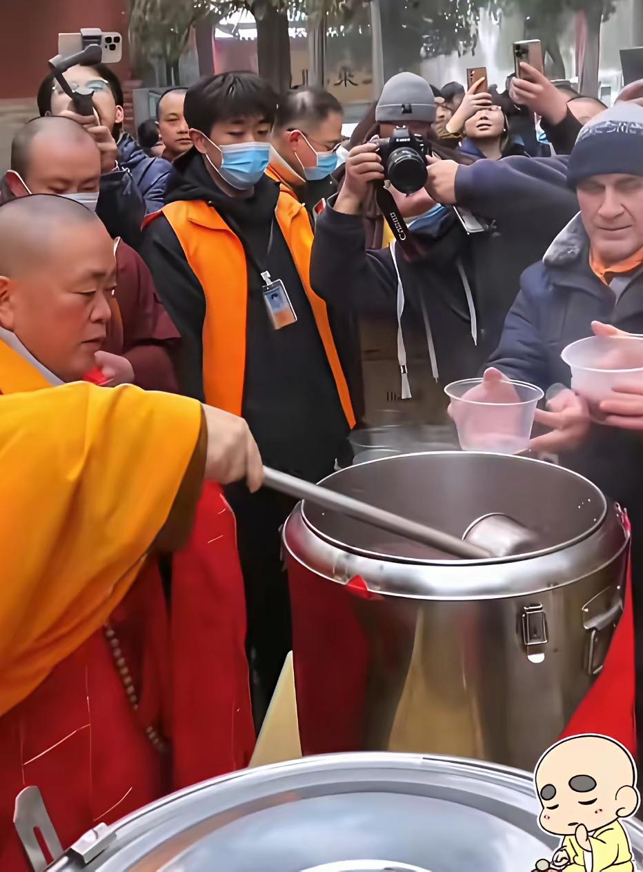 想当年的释永信大师为香客们盛粥时的一幕，四周围满摄像机跟拍。上传网络后，给人感觉