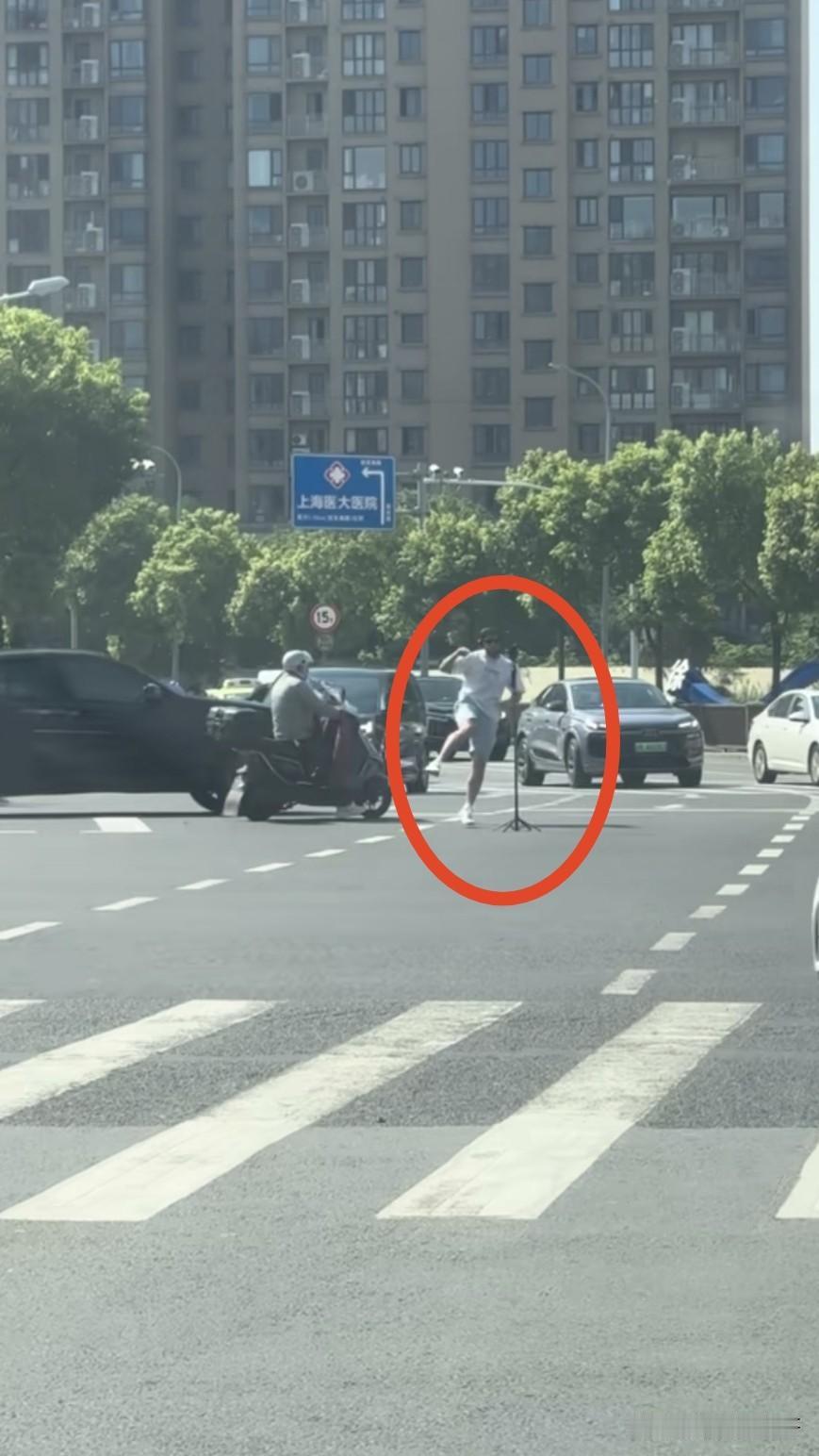 近日有网友拍到上海街头某路口，一外国人在车来车往的路上跳舞自拍，他认为此举不仅危