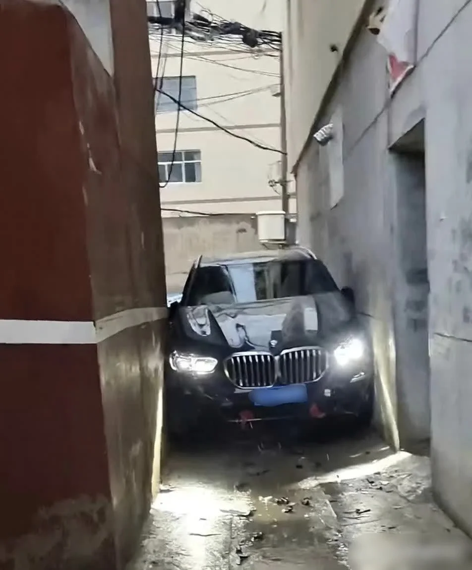 邻居为了不占地方把宝马X5开进了房屋中间的巷子，请问网友这下要损失多少钱呀？