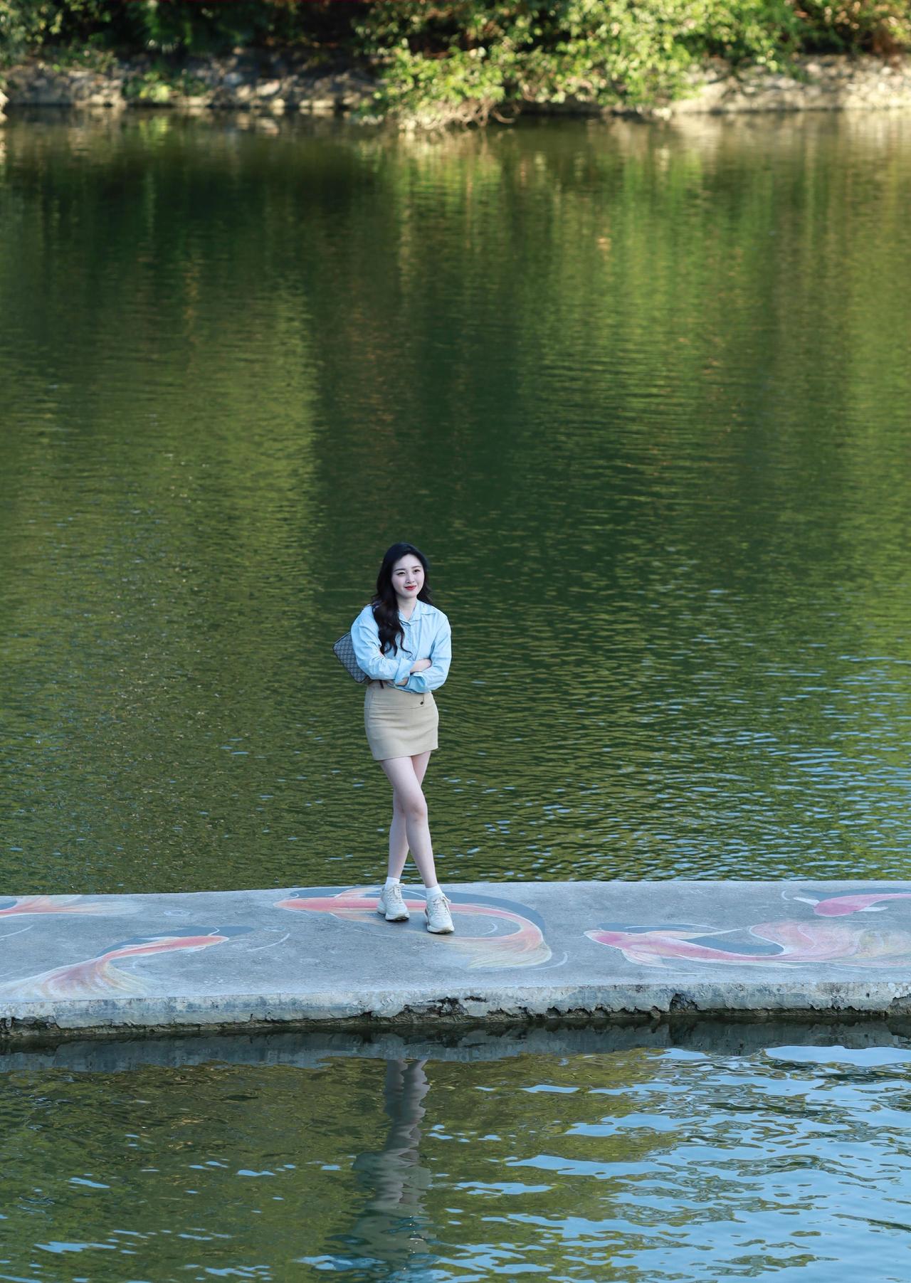 湖边，小姐姐笑容亲切。光影不错，可惜风有些大。光影的质感出不来。～～女生拍照姿势