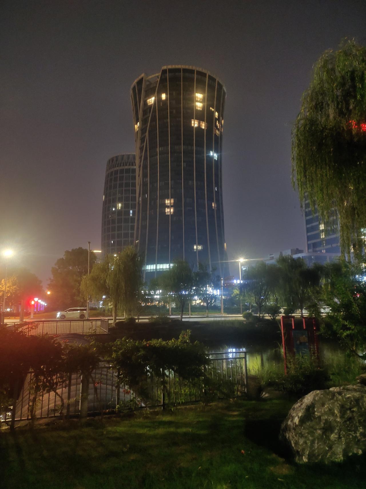 夜晚的都市风光，灯火辉煌的高楼与宁静的公园相映成趣。🌃