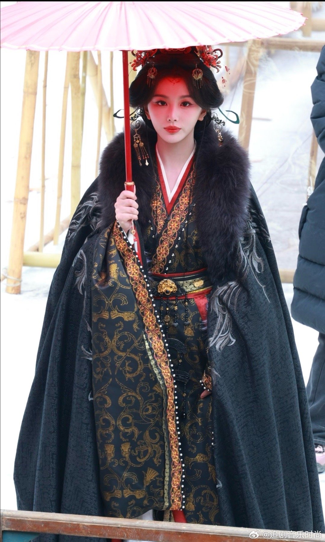 孔雪儿撑伞又出神图黑金着装配额上一抹红，雪中撑伞眼神带杀气，这不就是女帝本帝吗？