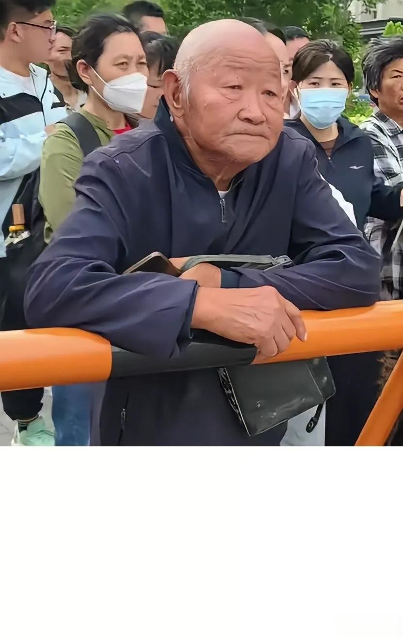 考场外，送考的人群里大多是爸妈，一眼就能看见一位穿着朴素的老爷爷。他77岁了，特