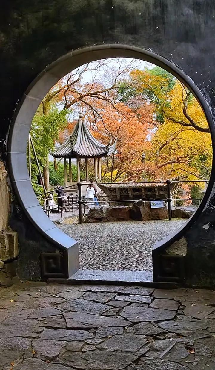 秋高气爽的日子就是适合赏景发呆的好时节！透过那古色古香的大门框，满眼的枫叶红得就