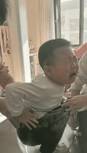 天呐！有个调皮男孩
一不小心坐进大玻璃瓶里出不来了，这可急坏了一旁的妈妈和奶奶。