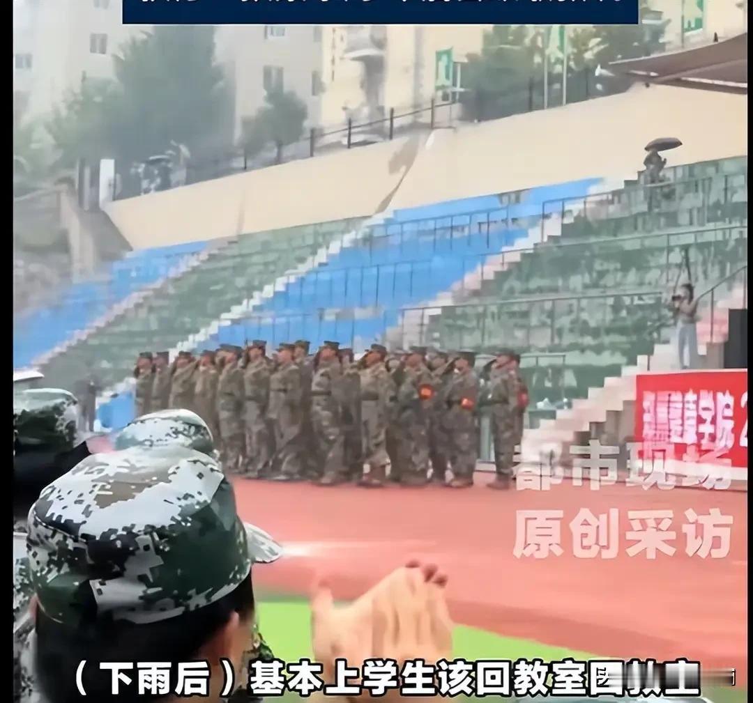 郑州健康学院新生军训会操，刚巧赶上下雨，于是学生淋着雨在操场上席地而坐，领导们则