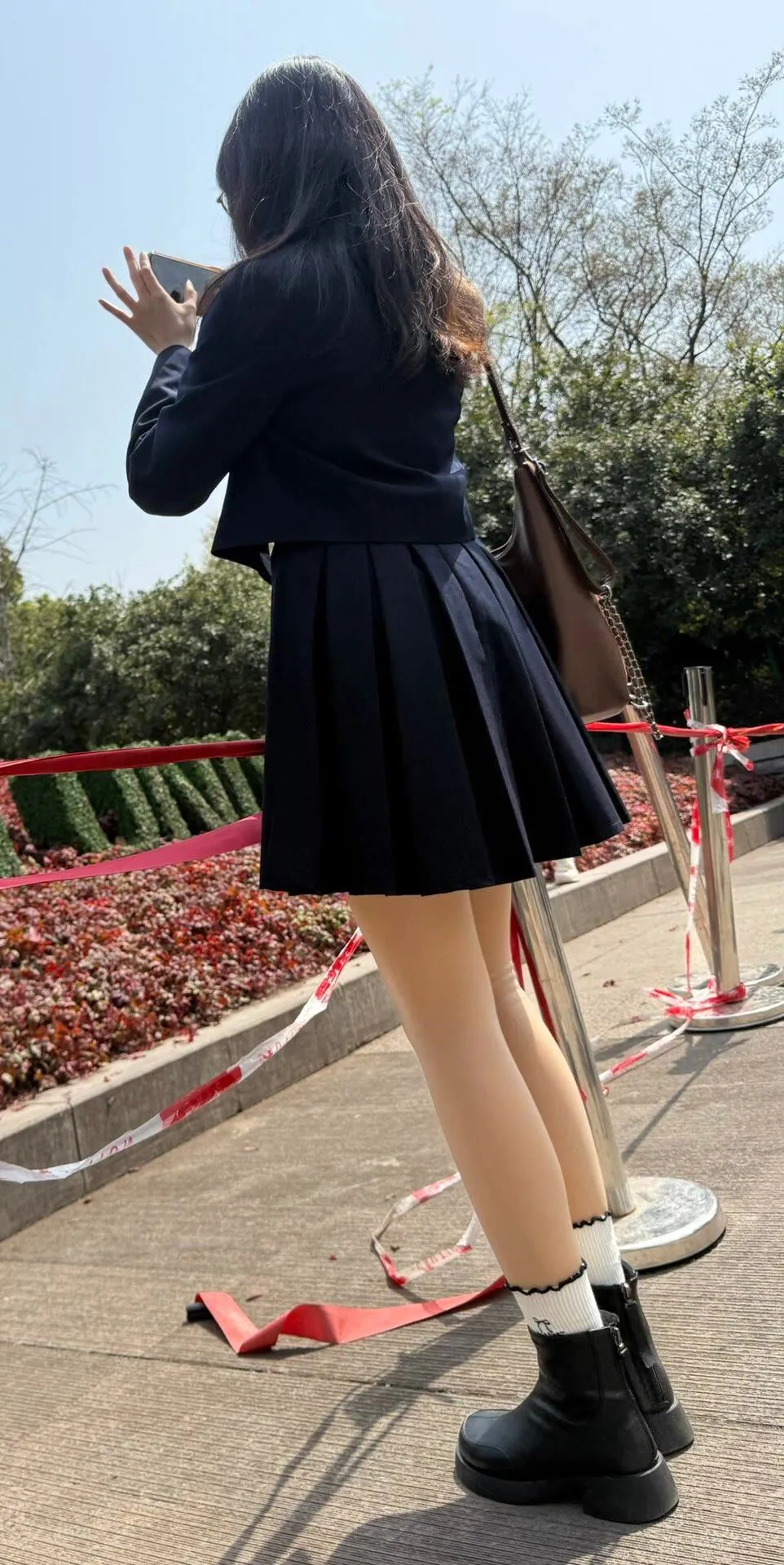 青春洋溢的校园时光，阳光下的少女，手机记录美好瞬间。 