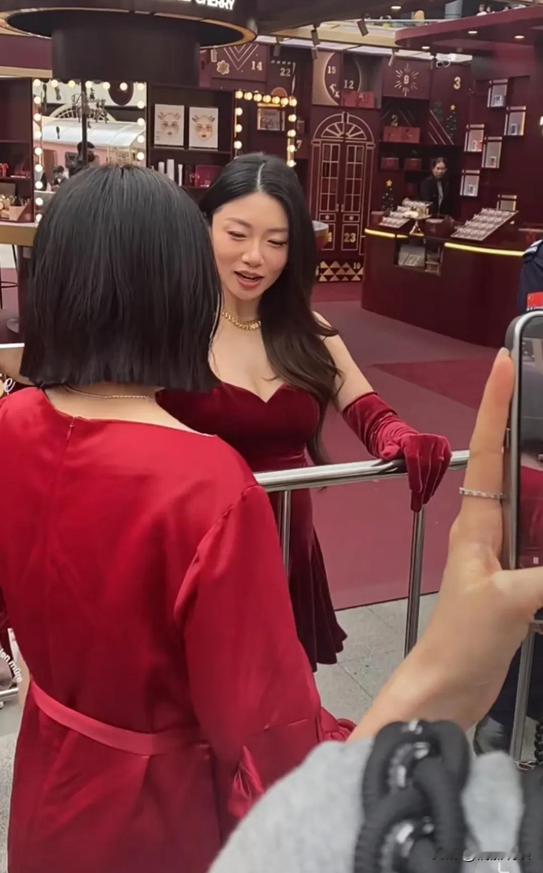 程晓玥现身香港，穿着一身酒红色低胸孕妇裙，胳膊上戴着同色手套。
她长发披肩，脸庞