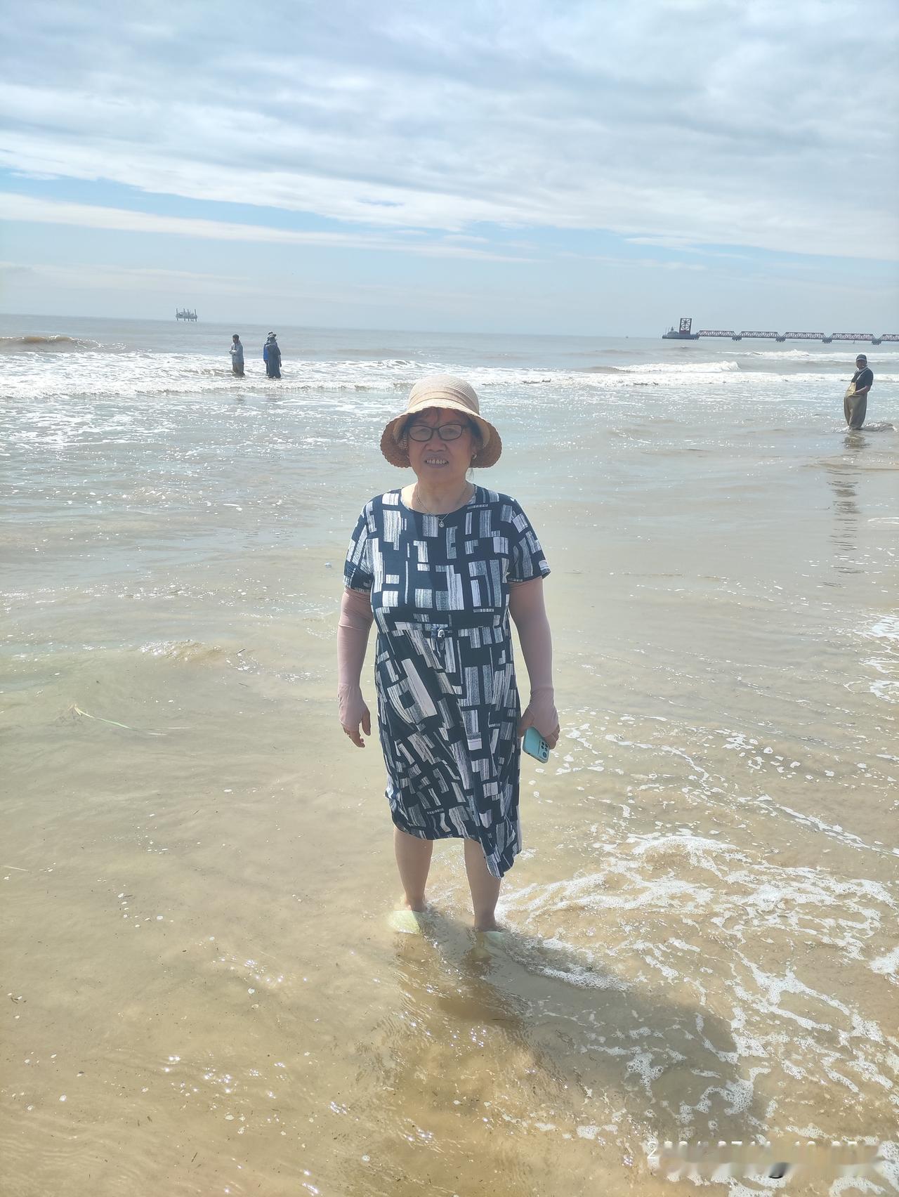 海风轻拂沙滩，浪花漫过脚边，温柔治愈。长辈漫步浅滩，踩碎层层白浪，面朝辽阔大海舒