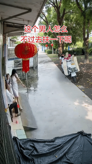 女孩刚走出家门口突然意外滑倒，最后重摔在了地上！
旁边的两名男子看到了竟然无动于