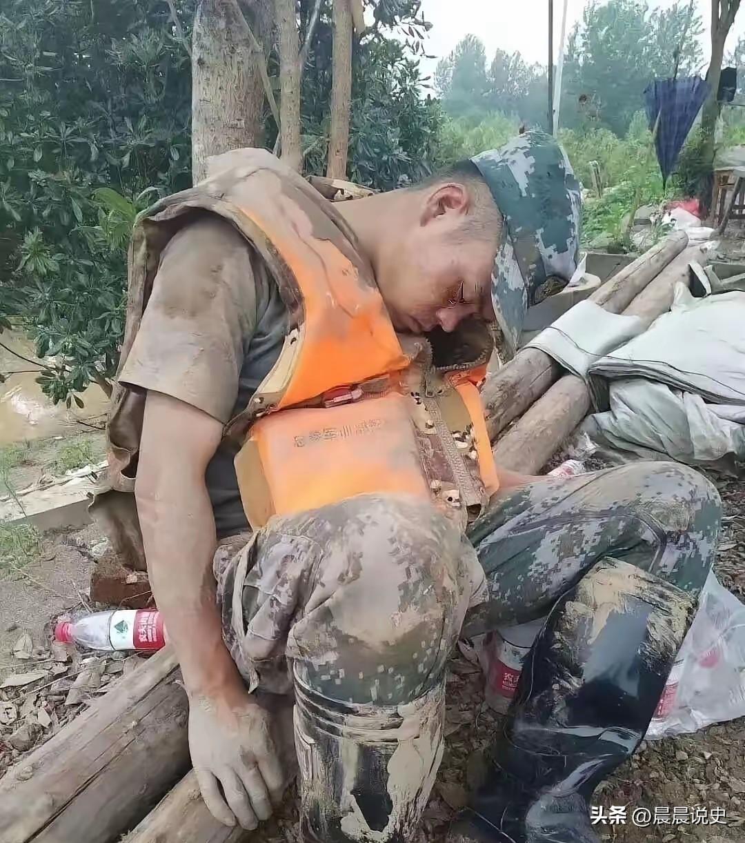 这张照片让无数人泪崩，一个满身淤泥的战士，累的靠在一棵树旁睡着了。
每每看到这些