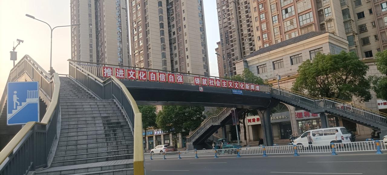 今天上班途中，看到过街天桥上的一幅标语，觉得有点意思，就随手拍了下来。
琢磨了一