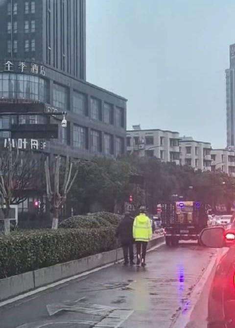 杭州女交警铁骑50米走了4分10秒杭州女交警雨中陪老人走完50米，用时4分10秒
