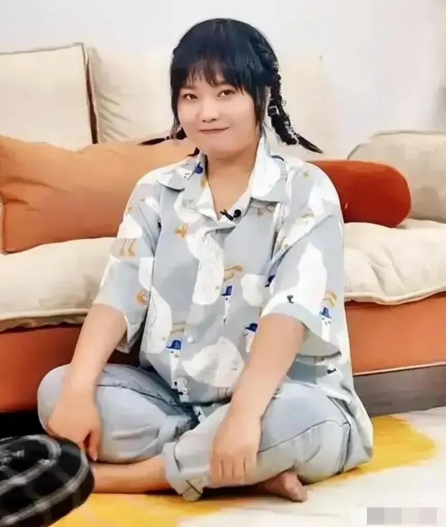 画面中的李雪琴衣着素朴，身宽体胖，肤白脖短，柳眉杏眼，唇薄鼻塌，不过盘腿而坐的造