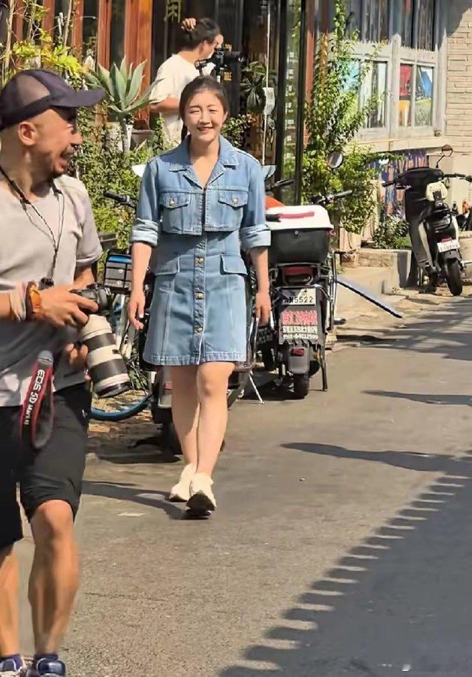 陈梦已经回到了北京了，一个人逛街，穿着非常时尚时髦，穿着牛仔连衣裙，扎着马尾，很