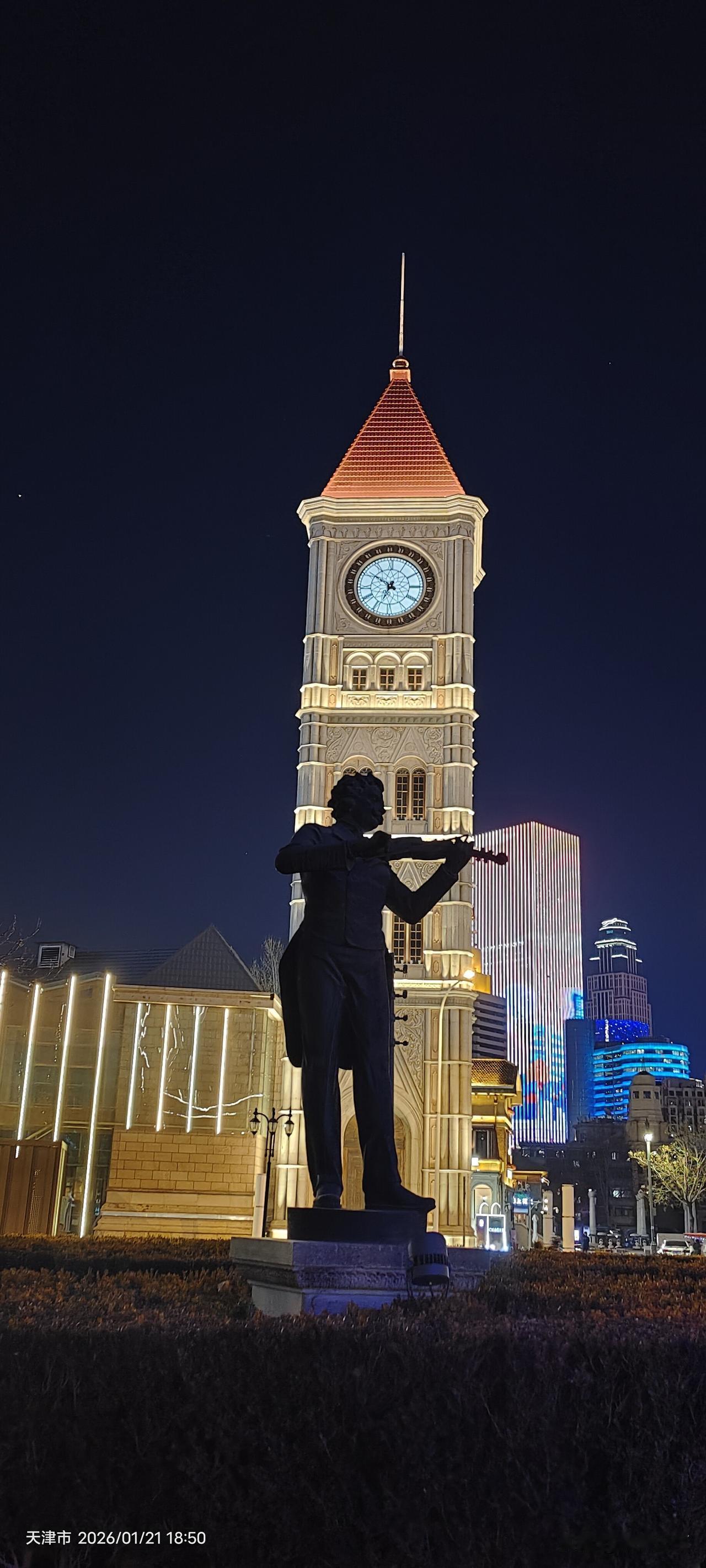 📸 专业点评与评分
 
照片主体：天津意风区钟楼与小提琴手雕像夜景
 
 
 