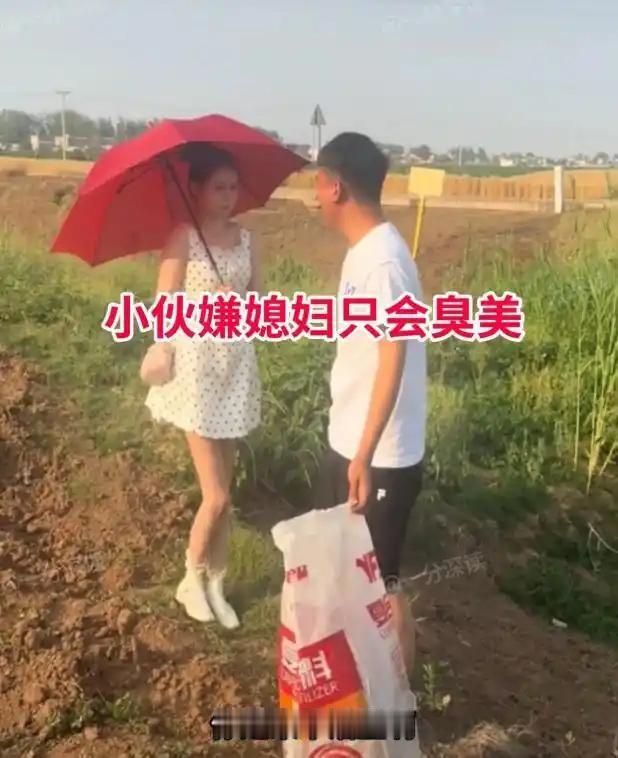 夫妻俩下地干农活，妻子穿了漂亮的波点短裙，撑着一把红伞跟在身后。男人一看就来了火