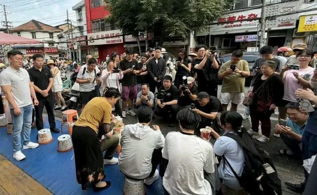 本该是安逸吃早点的寻常场面，却被一众举着手机、相机的人群围得水泄不通，里三层外三