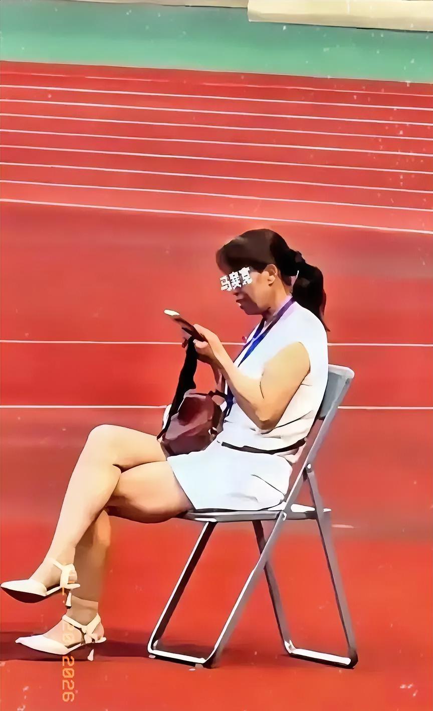 全网都在关注陇超这名女子的相关情况，她坐在一张椅子上，翘着二郎腿，刷着手机，脖子