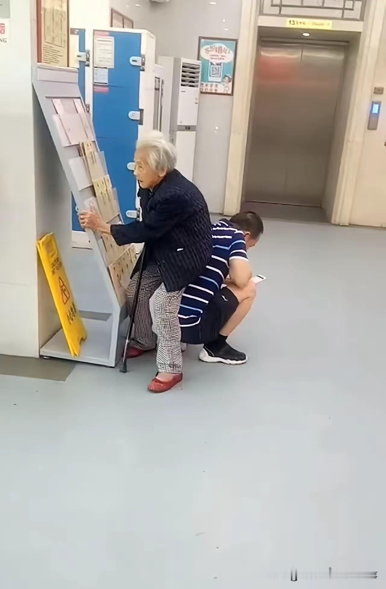 医院走廊里人满为患，一位老人在儿子的陪同下前来看病，可放眼望去，连走廊的公共凳子