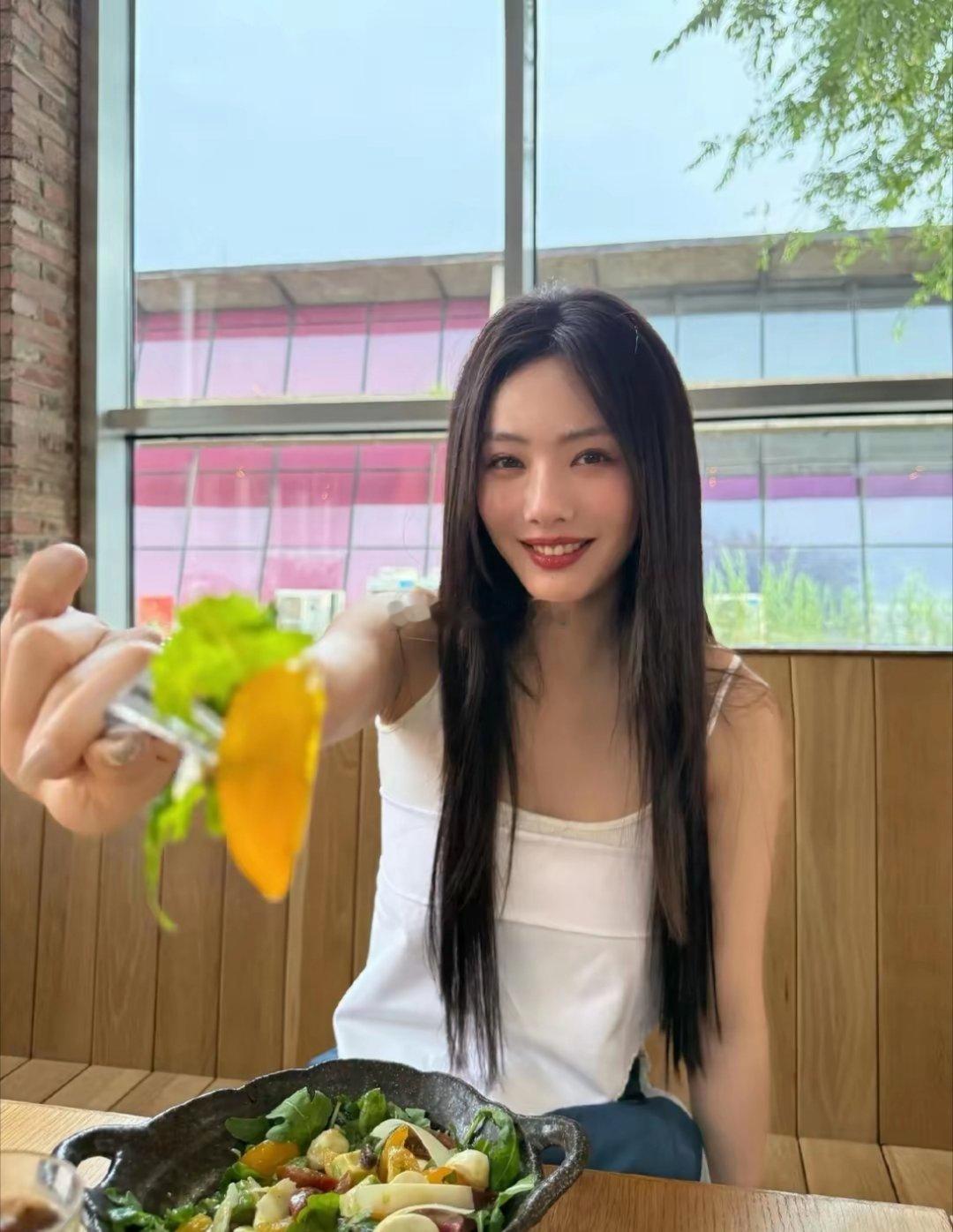 蔡文静分享美照，她身穿白色吊带衣，喝着果汁，吃着美食，十分惬意。 ​​​