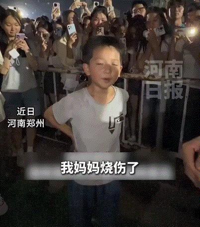 6月30日报道，郑州街头，一个8岁小男孩站在人群中间，落落大方地帮烧伤的妈妈吆喝