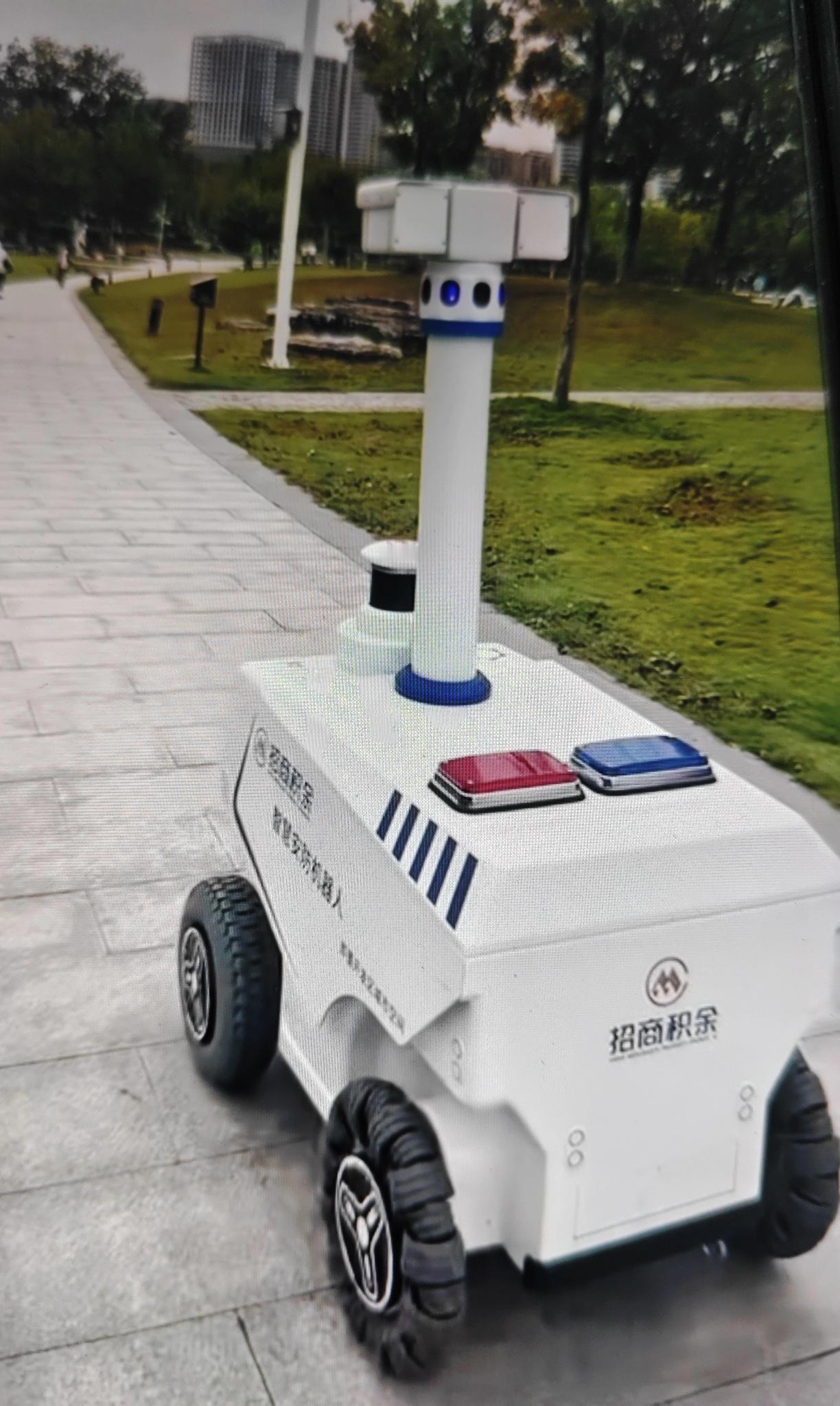 即墨创智新区龙泉湖公园最近出现了一台智慧安防机器人，它有四个轮子，顶部有摄像头，