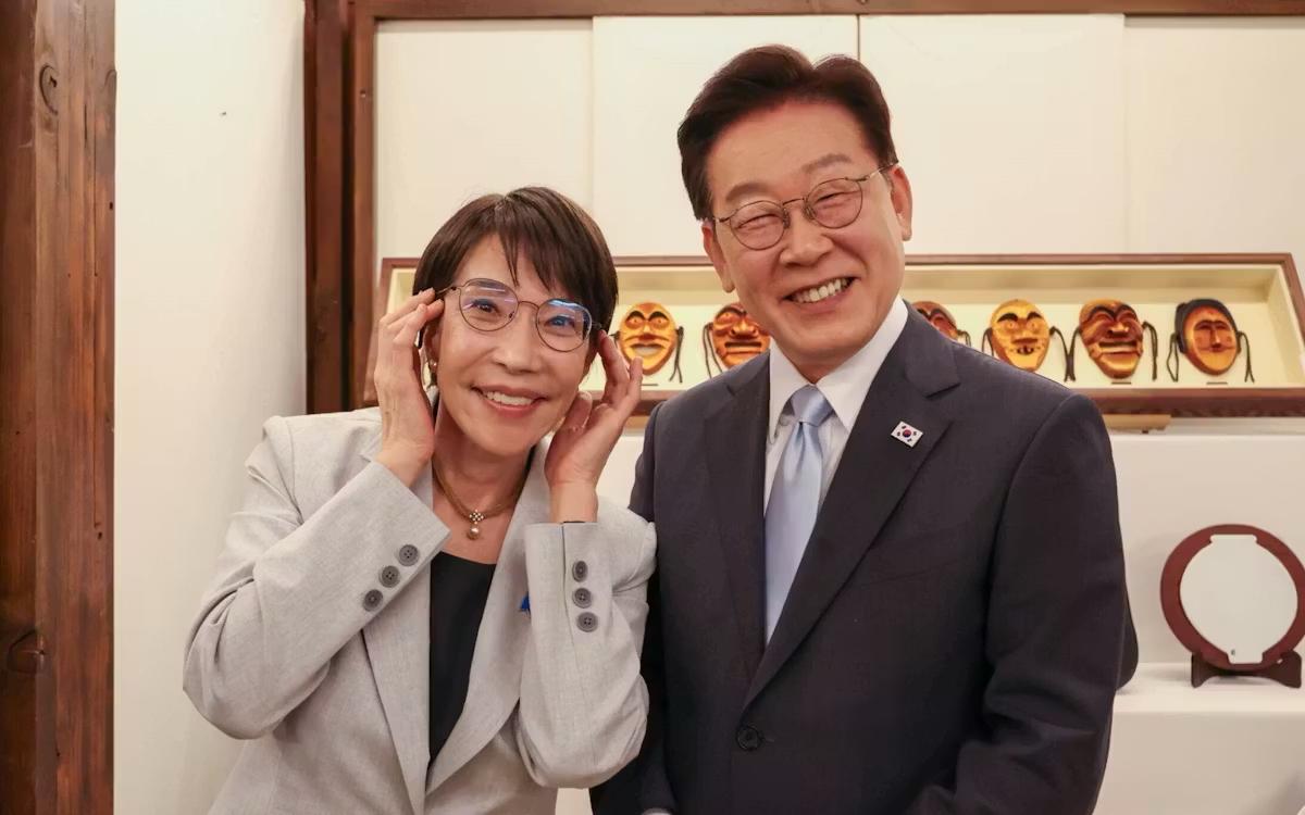 高市早苗送给韩国李在明一副眼镜，还卖萌戴着眼镜，两个人都是眯着眼睛露出牙齿笑着，