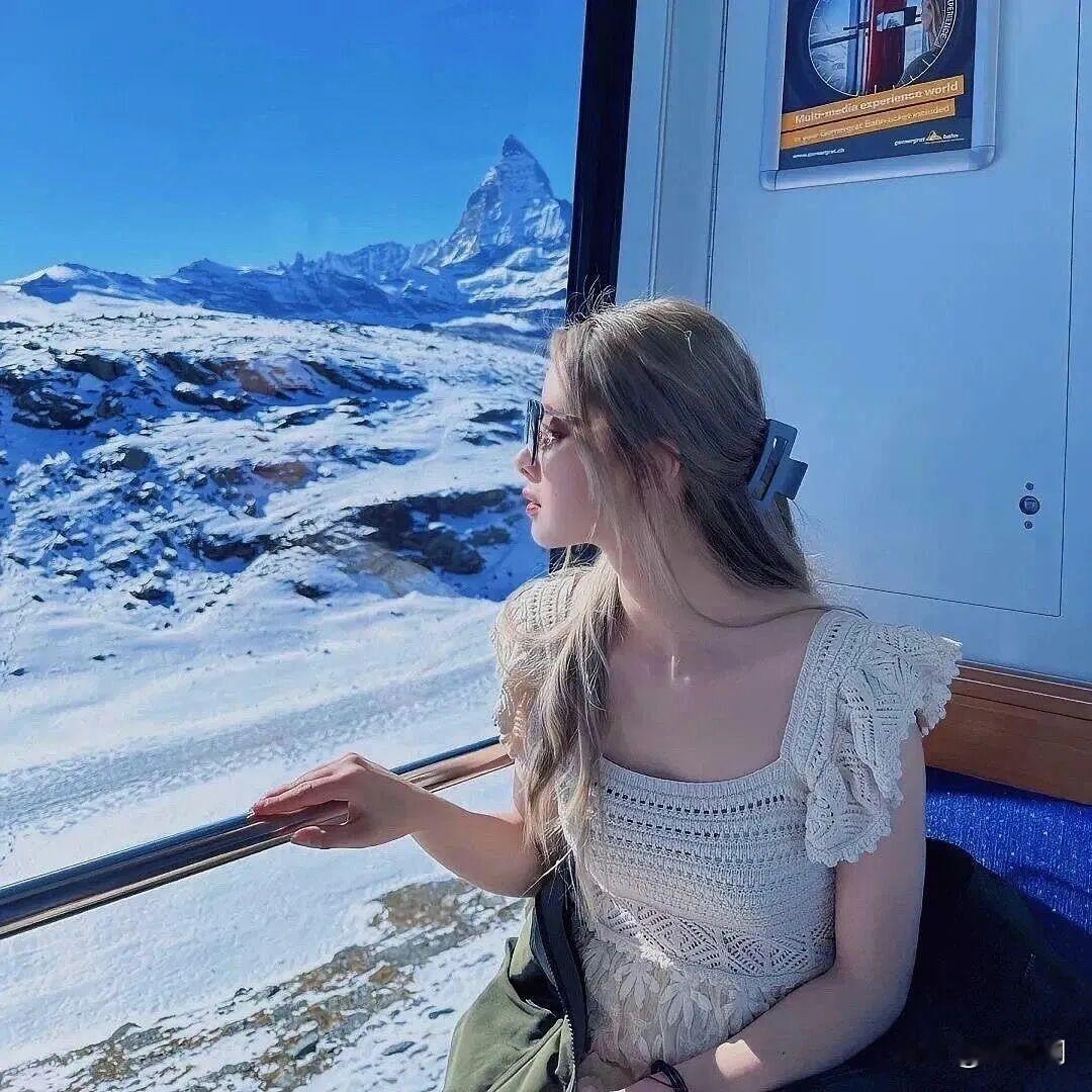 窗含雪岭耸冰峰，云绕马特锥影重。
素袂轻依车槛侧，凝眸遥对玉芙蓉。
晴光遍洒千岩