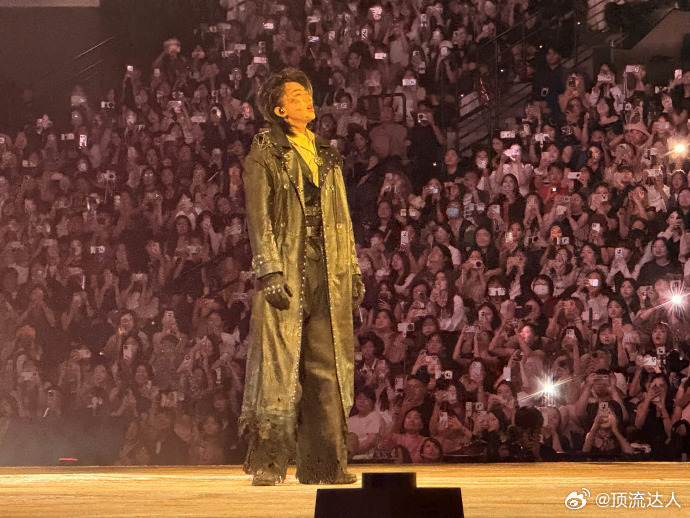蔡徐坤演唱会弹唱礼帽加复古风衣，蔡徐坤西部牛仔造型亮眼，手持电吉他带来弹唱舞台。