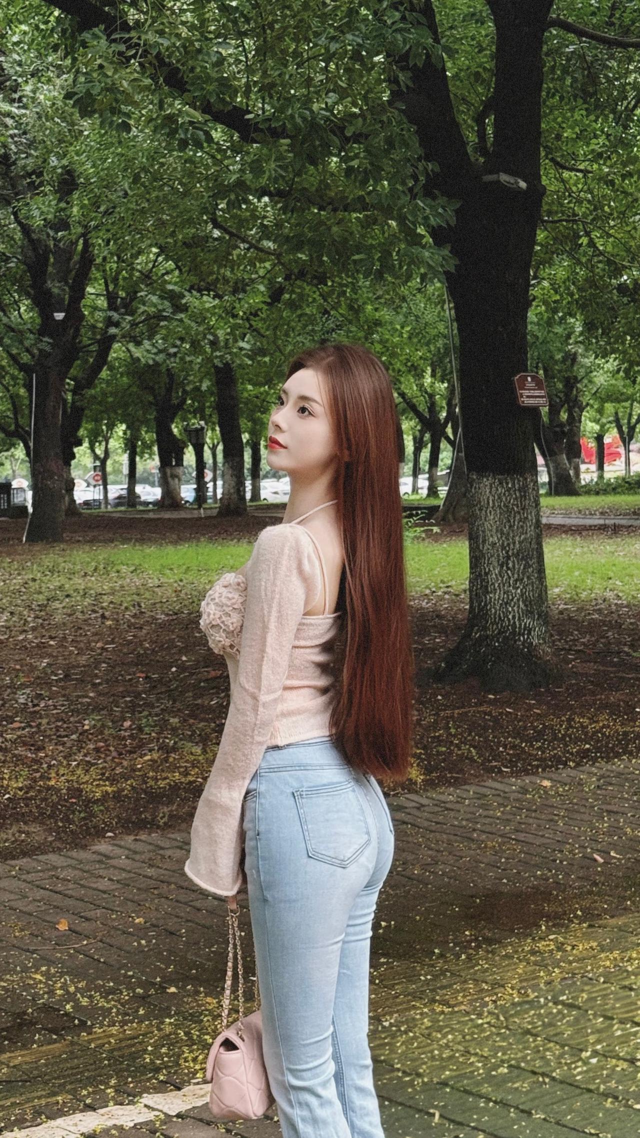 绿意中的灵动芳华
漫步于葱郁的林间小道，她宛如自然书写的诗意篇章。那一头如绸缎般