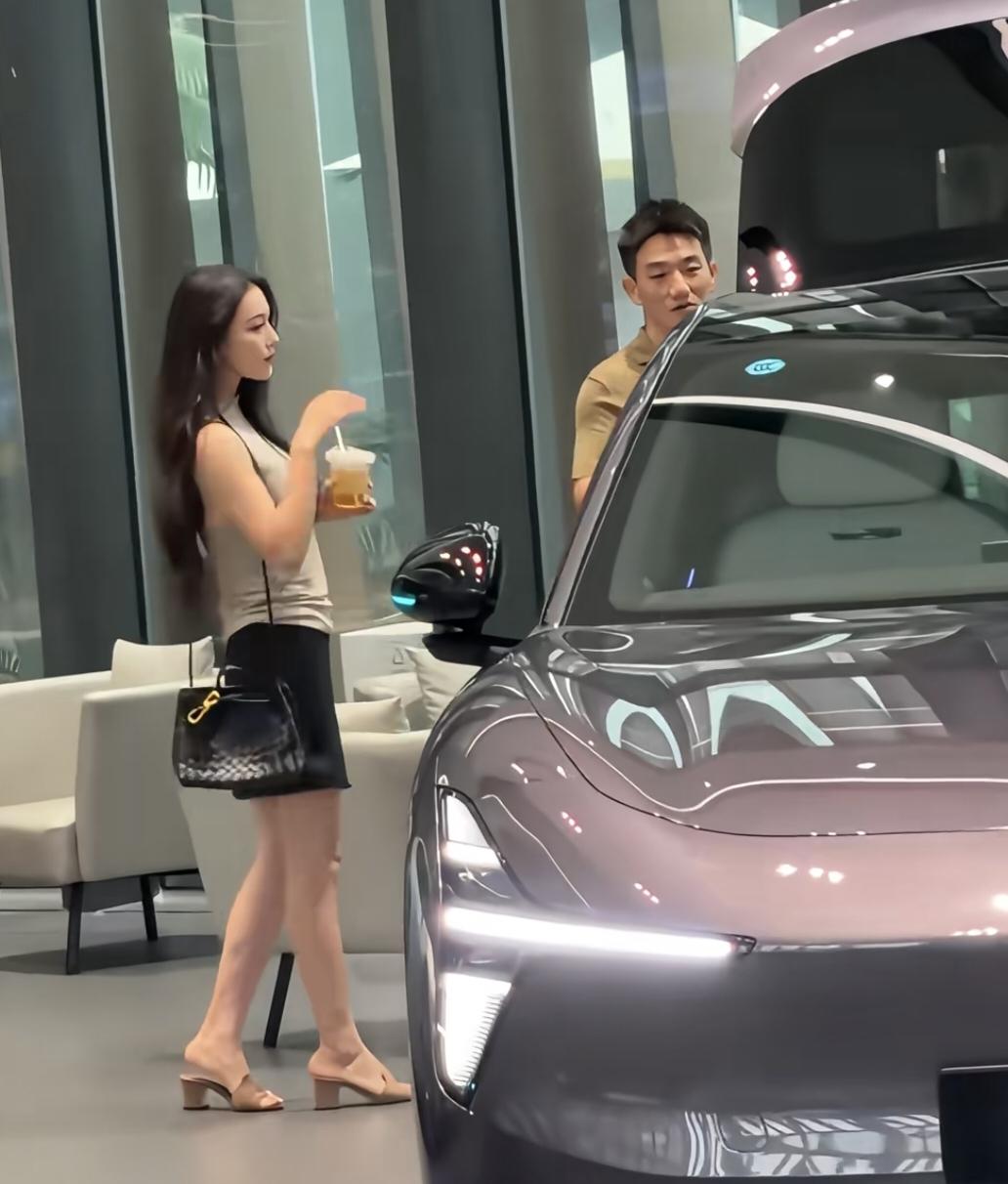 39岁张馨予和老公何捷现身广州一间车企看豪车，她背着4万元的名牌包，打扮时尚贵气